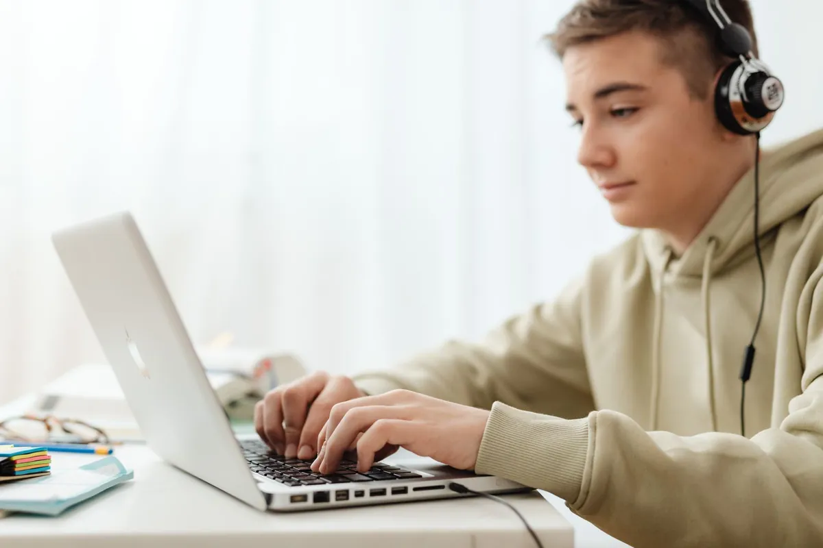 A teen taking the online BDE course on a laptop at home