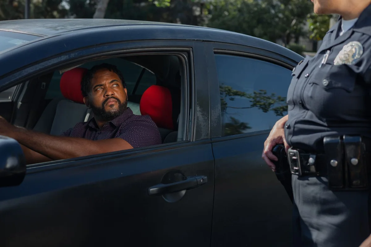 A driver being issued a ticket at a roadside traffic stop